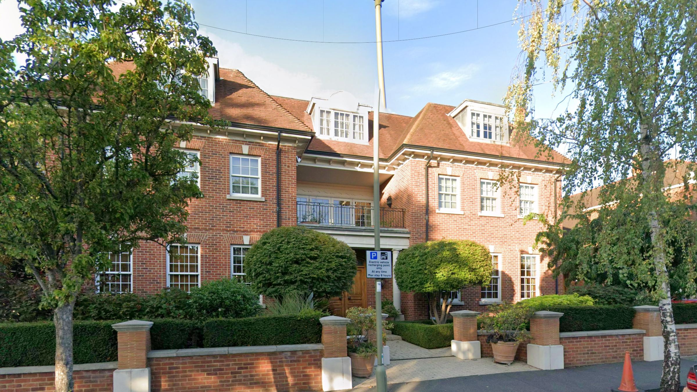 Front elevation of 36 Cranbourne Gardens: a three-storey red-brick house with a columned portico and wrought-iron balcony